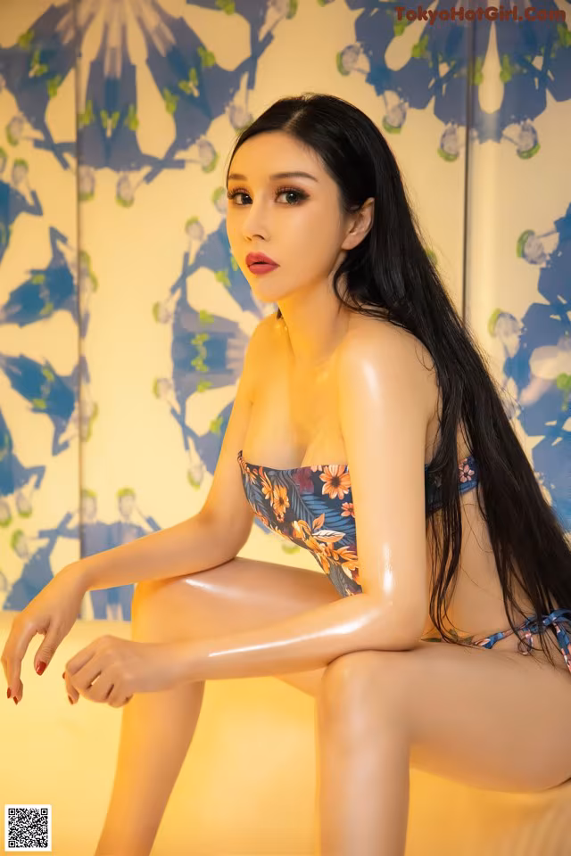A woman in a bikini sitting on a table.