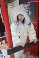 A woman wearing a white coat and a fur hat.