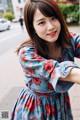 A woman in a blue dress with red flowers on it.