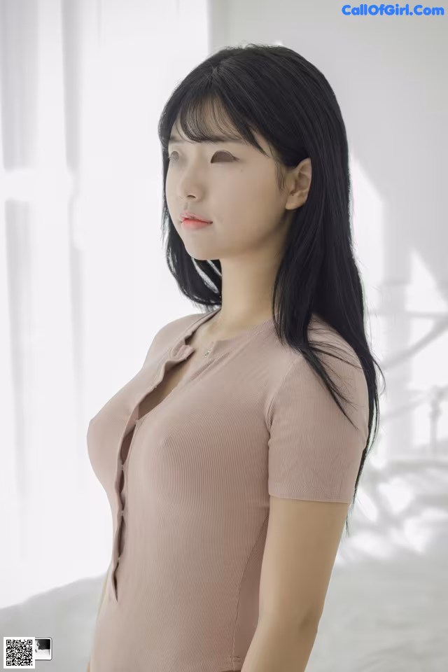 A woman in a pink shirt is posing for a picture.