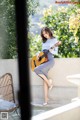 A woman sitting on a ledge playing a guitar.