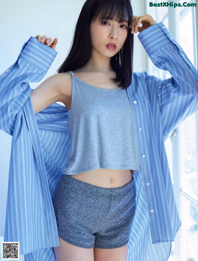 A woman in a blue and white striped shirt and shorts.