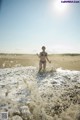 A woman in a bikini running into the ocean.