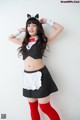 A woman in a maid outfit posing for a picture.