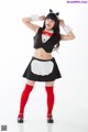 A woman dressed in a maid outfit posing for a picture.